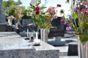 Bouquet de fleurs et bougies déposés sur une pierre tombale pour un hommage.