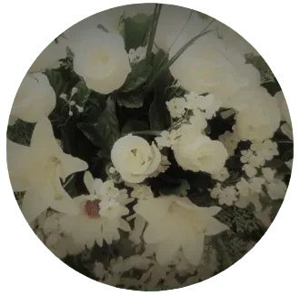 Composition ronde de fleurs blanches et de lys pour des obsèques.
